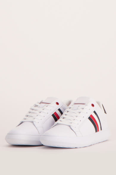 Baskets blanches de TOMMY JEANS, avec rayures latérales rouges, blanches et bleues.