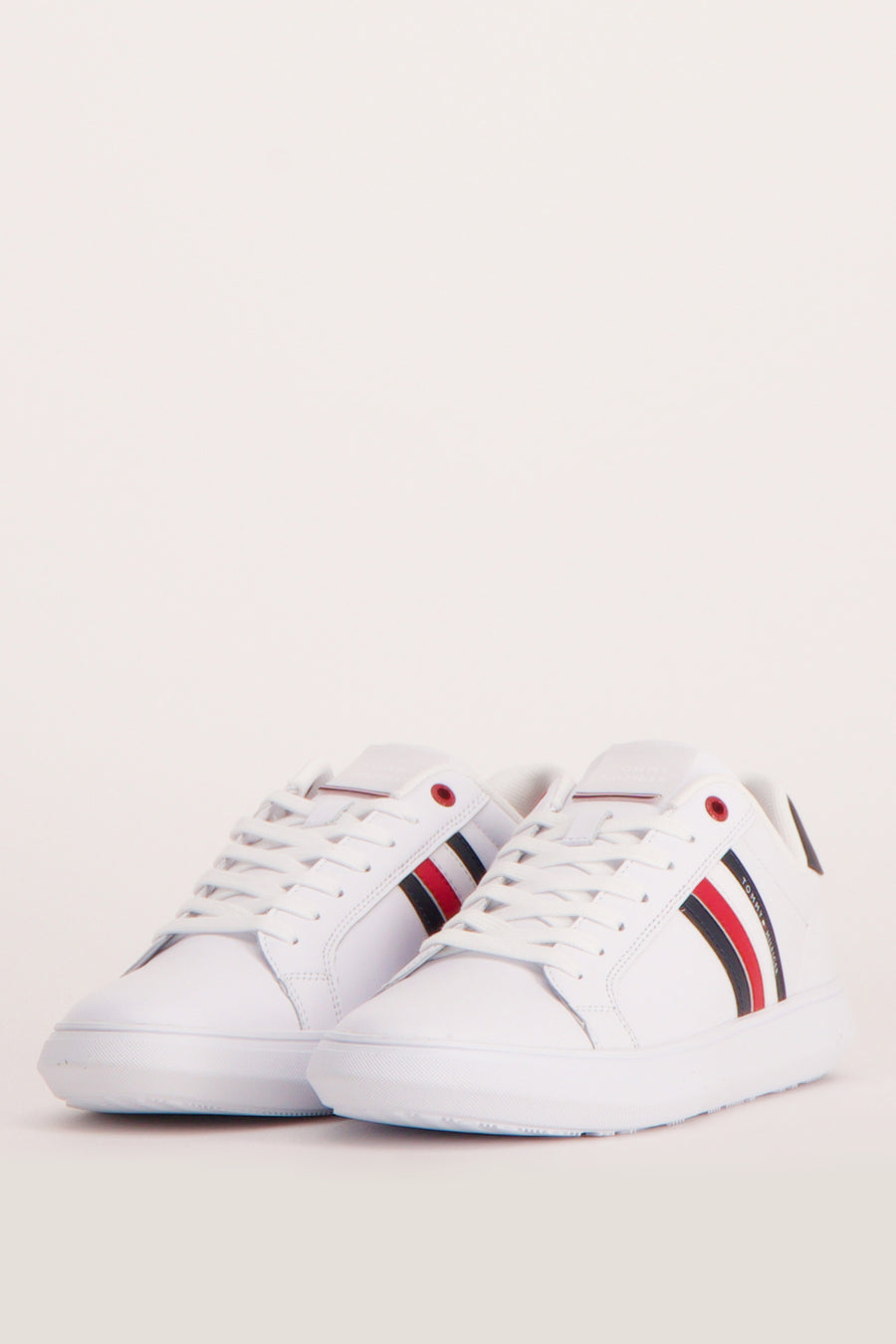 Baskets blanches de TOMMY JEANS, avec rayures latérales rouges, blanches et bleues.