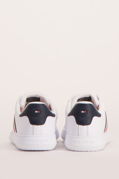 Baskets blanches de TOMMY JEANS, vue arrière avec logo et accents bleu marine et rouge.