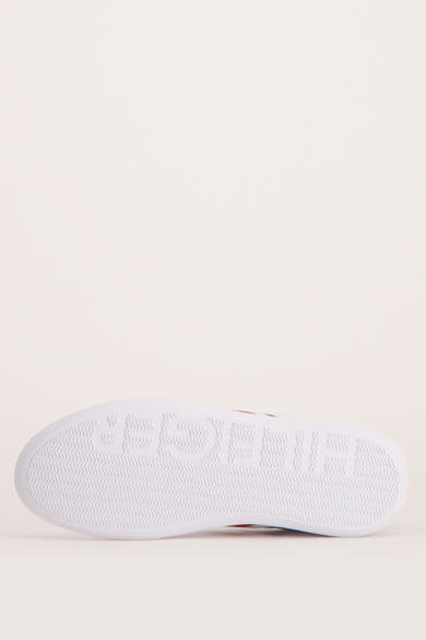 Semelle blanche de baskets TOMMY JEANS, avec un motif ondulé et le lettrage de la marque en relief.
