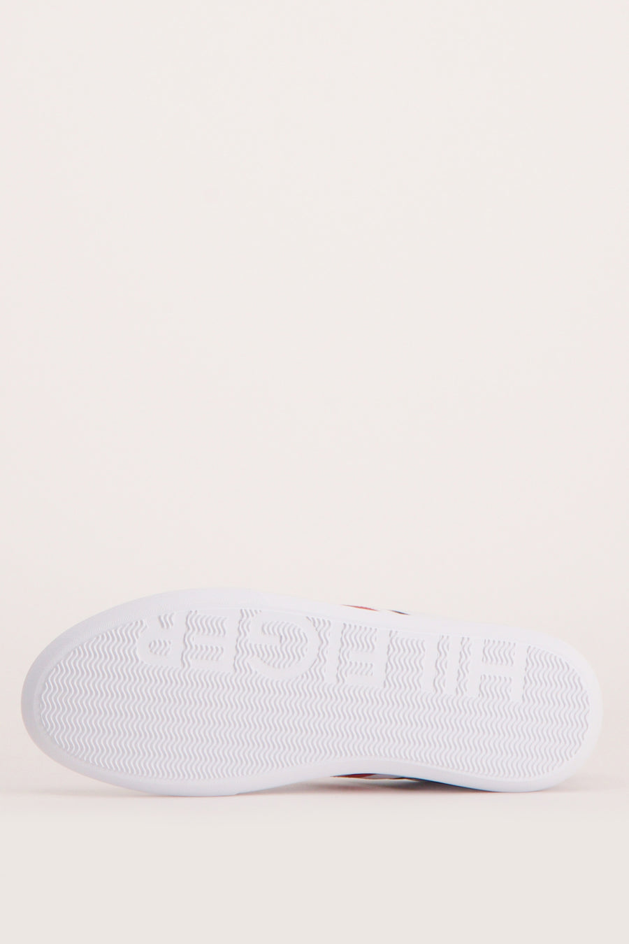 Semelle blanche de baskets TOMMY JEANS, avec un motif ondulé et le lettrage de la marque en relief.
