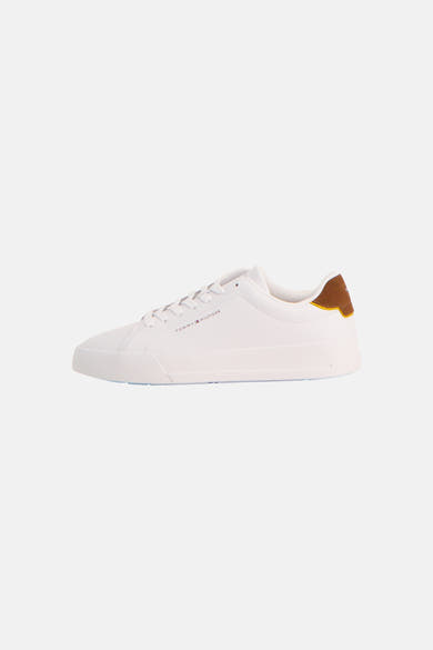 Sneakers blanches de TOMMY JEANS avec un talon marron et jaune, vue de côté.