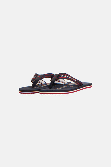 Blauwe teenslippers van TOMMY JEANS, met rode en witte strepen op de zool.