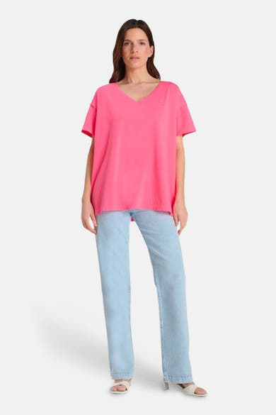 T-shirt rose à manches courtes de Le Temps des Cerises, porté avec un jean bleu clair.
