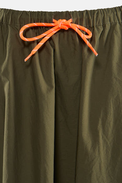 Jupe kaki 3/4 de Le Temps des Cerises, avec cordon de serrage orange à la taille.