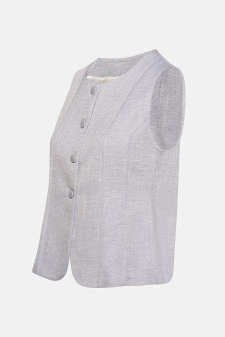 Lichtblauwe blazer van AMELIE ET AMELIE, mouwloos model, geweven textuur en knoopsluiting, zijwaarts bekeken.