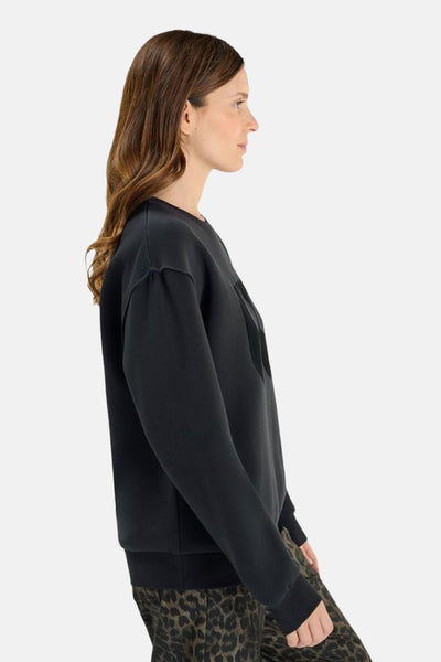 Donkerblauwe rondehals sweatshirt van Le Temps des Cerises, met opdruk aan de voorkant en gedragen met een luipaardprint broek.
