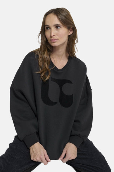 Donkerblauwe sweater van Le Temps des Cerises, met een groot zwart logo op de voorkant.