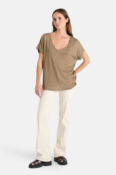 Kaki T-shirt met korte mouwen van Le Temps des Cerises, gedragen met een witte spijkerbroek en zwarte sandalen.