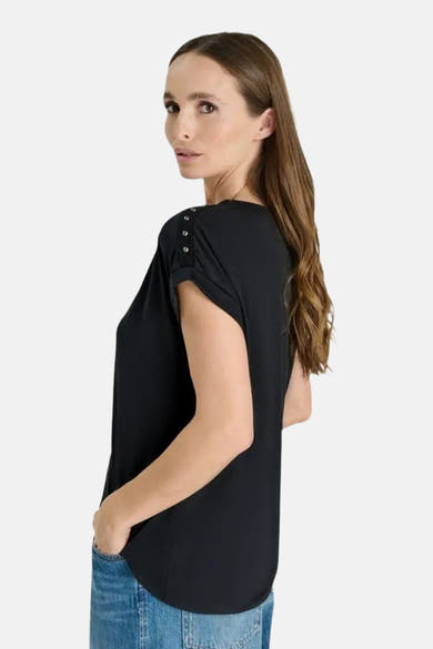 T-shirt noir à manches courtes de Le Temps des Cerises, vue de profil, avec boutons décoratifs sur l'épaule, porté avec un jean bleu