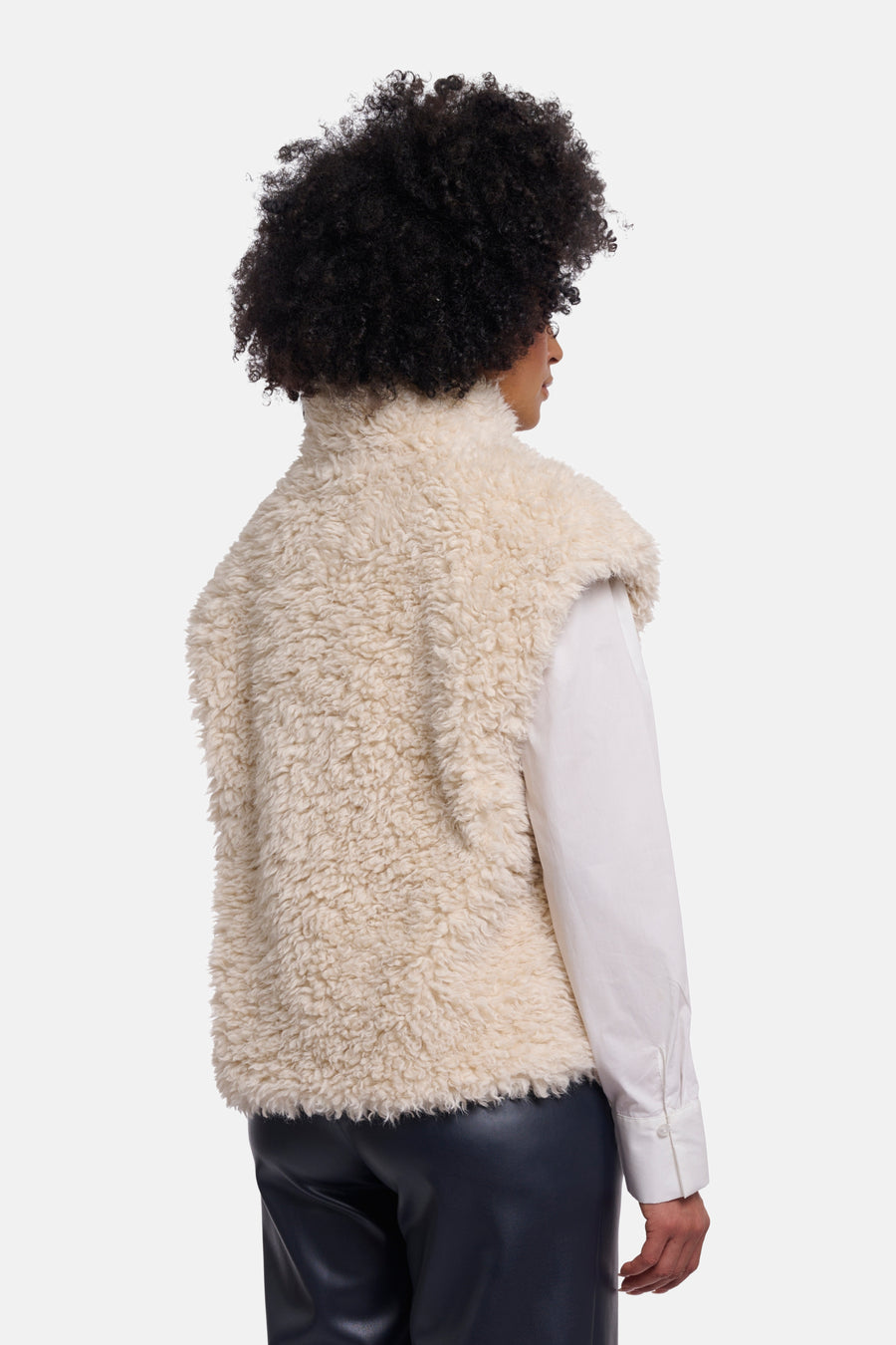 Ecru shearling bodywarmer by RINO PELLE, side view, plush texture, high collar, worn with white shirt and black leather pants