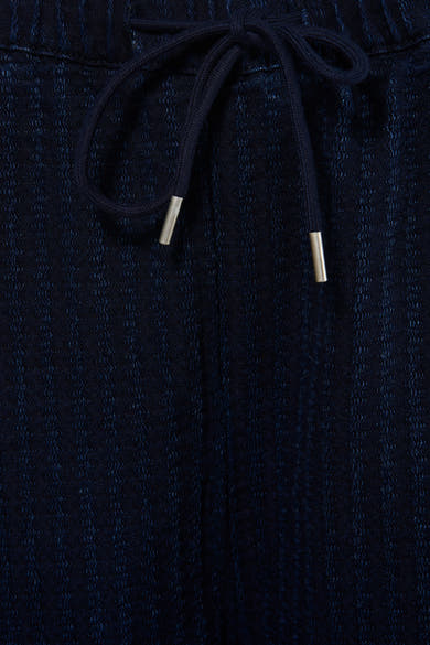 Pantalon en denim bleu foncé d'ADORE, avec une ceinture à cordon de serrage et un subtil motif texturé.