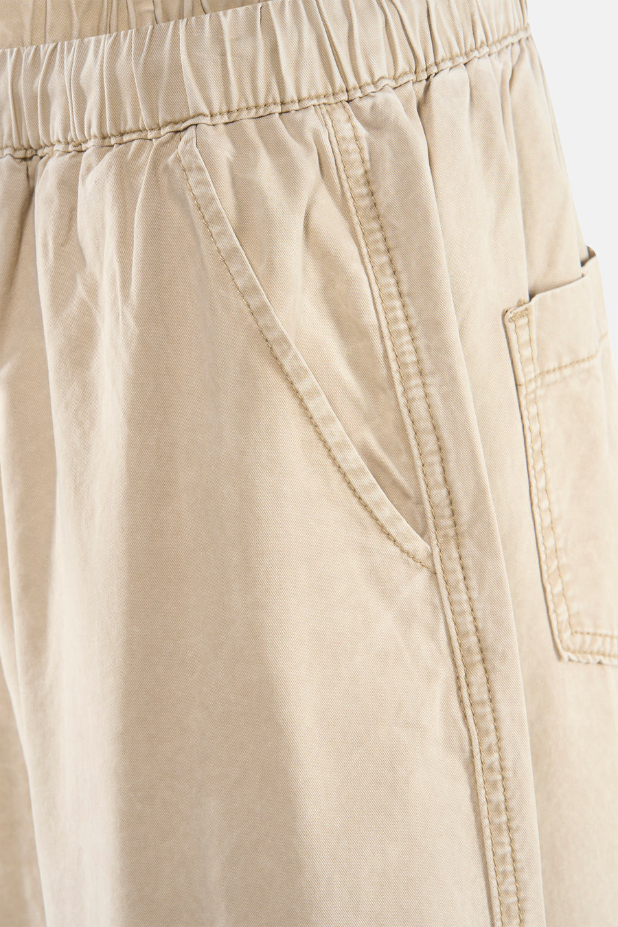 Pantalon beige par ADORE, avec taille élastiquée et poches latérales apparentes.