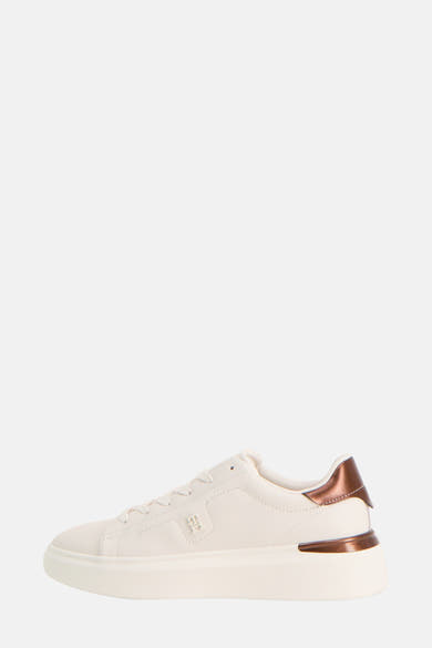 Baskets blanches de TOMMY JEANS, avec empiècement bronze métallique au talon et logo discret sur le côté.
