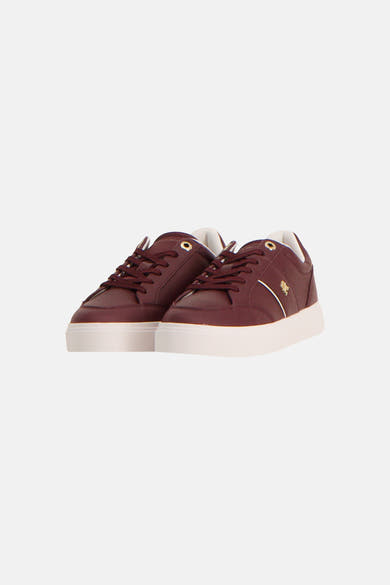 Burgundy leather sneakers by TOMMY JEANS with white rubber sole, gold-tone eyelets, and side logo detail, front view