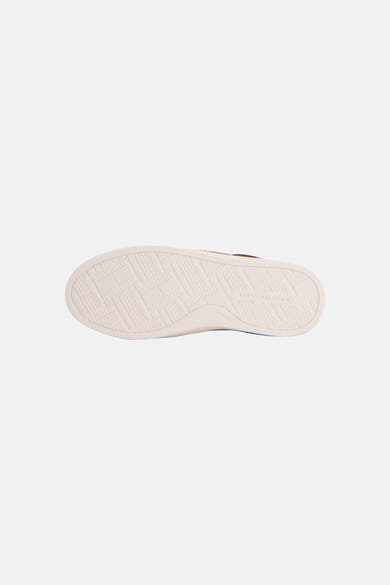 Red sneakers by TOMMY JEANS, white rubber sole with geometric tread pattern, bottom view