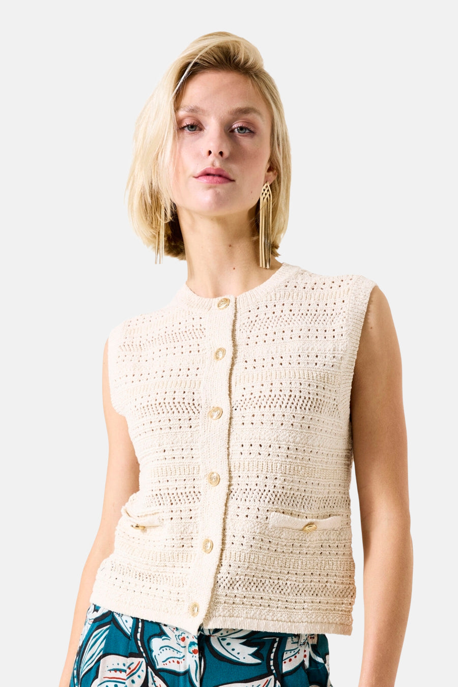 Ecru gilet van GARCIA met klepzakken, gouden knopen en gehaakte textuur, gedragen met een bedrukte broek.