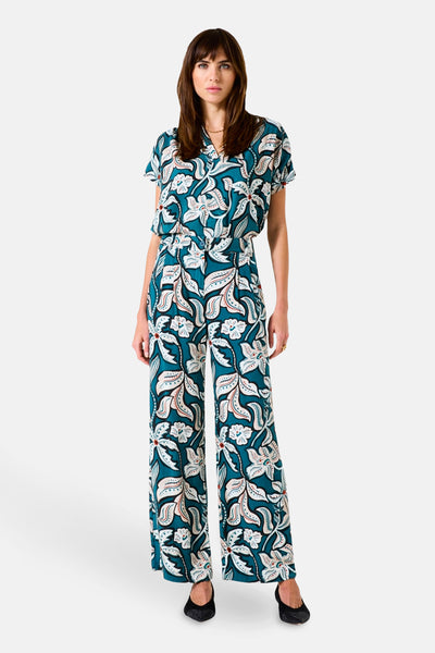 Multikleurige broek van GARCIA, met all-over bloemenprint, wijde pasvorm, gedragen met zwarte pumps.