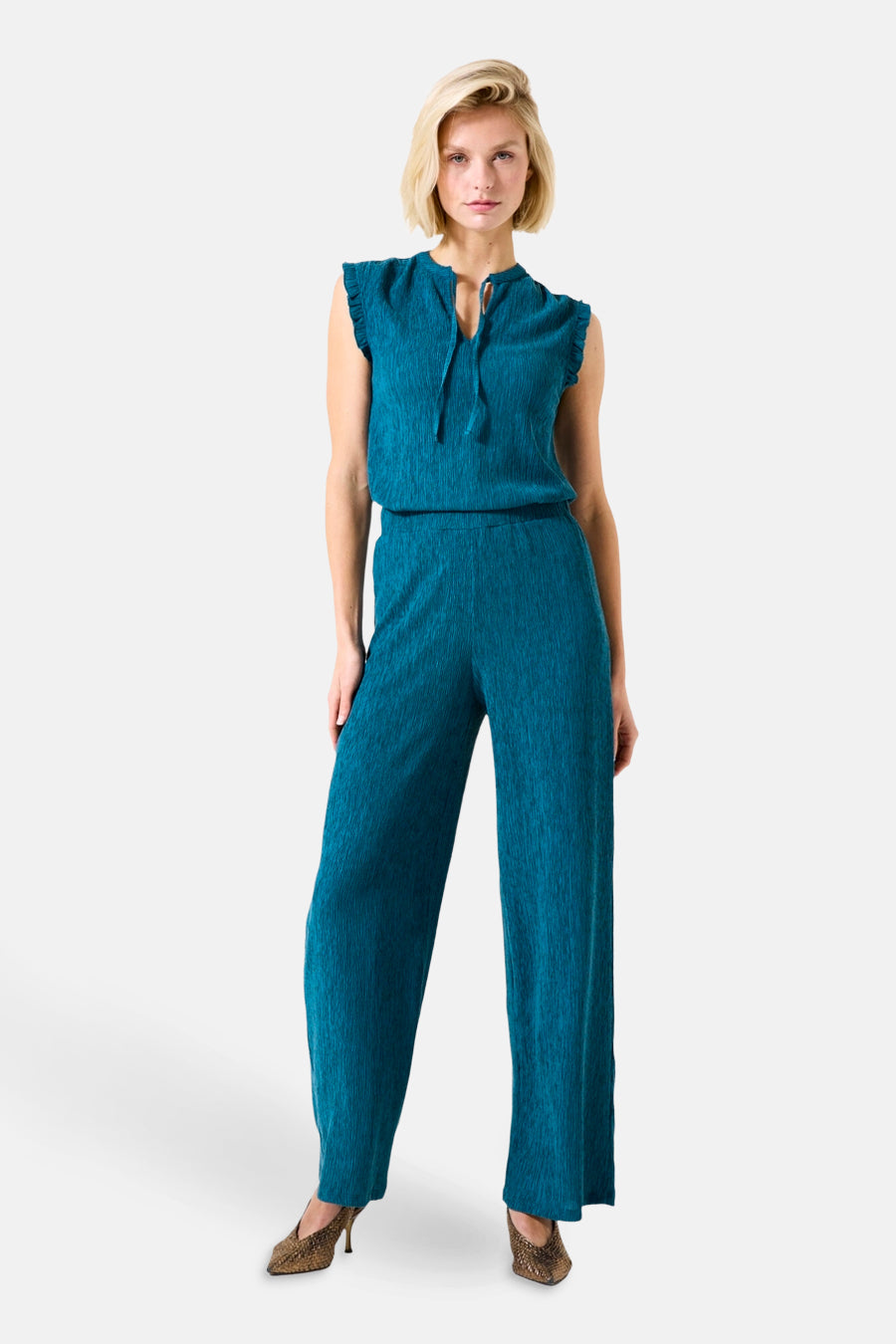 Turquoise geplooide broek van GARCIA, gedragen met een bijpassend topje en pumps met patroon.