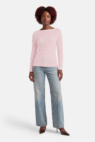Roze T-shirt met lange mouwen van AMELIE ET AMELIE, met kanten patroon, gedragen met een wijde spijkerbroek en bruine pumps.