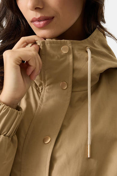 Veste courte beige de GARCIA avec capuche à cordon et boutons dorés, détail du poignet élastiqué.
