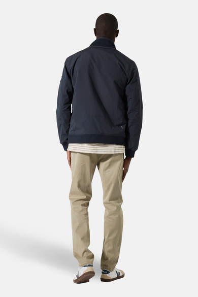 Veste courte bleue de GARCIA, vue de dos, portée avec un t-shirt rayé et un pantalon chino beige.