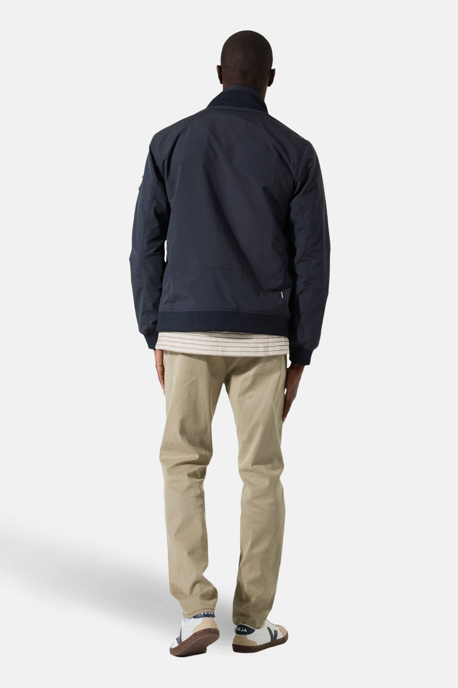 Veste courte bleue de GARCIA, vue de dos, portée avec un t-shirt rayé et un pantalon chino beige.