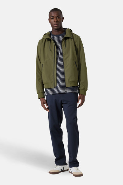 Imperméable olive par GARCIA, porté avec un t-shirt rayé bleu marine et blanc et un pantalon bleu marine.
