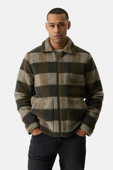 Khaki plaid fleece jacket with front zipper and two patch pockets, worn by model in lifestyle front view
