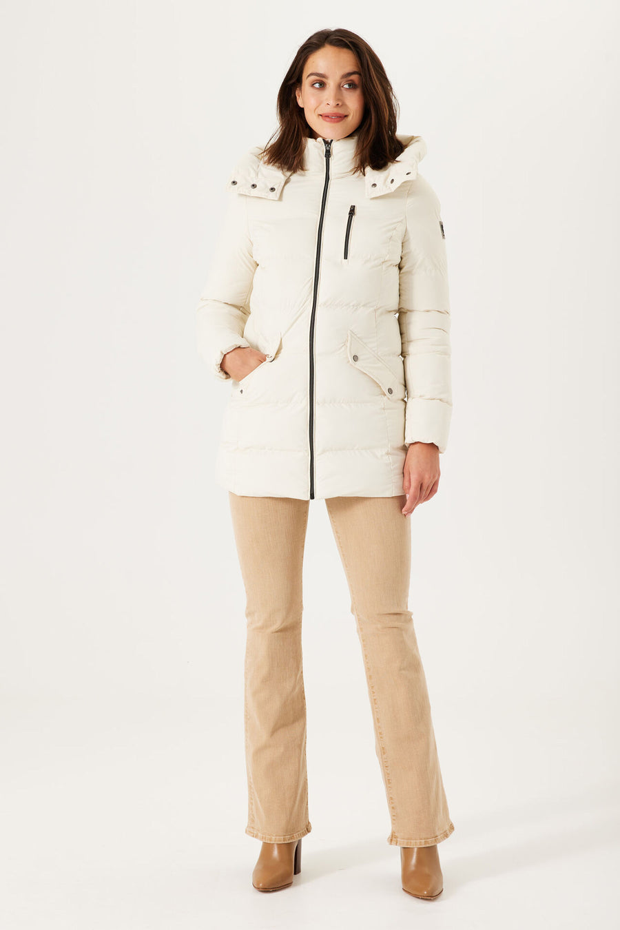 Ecru korte jas van GARCIA, met capuchon en zwarte ritssluiting, gedragen over een beige broek.