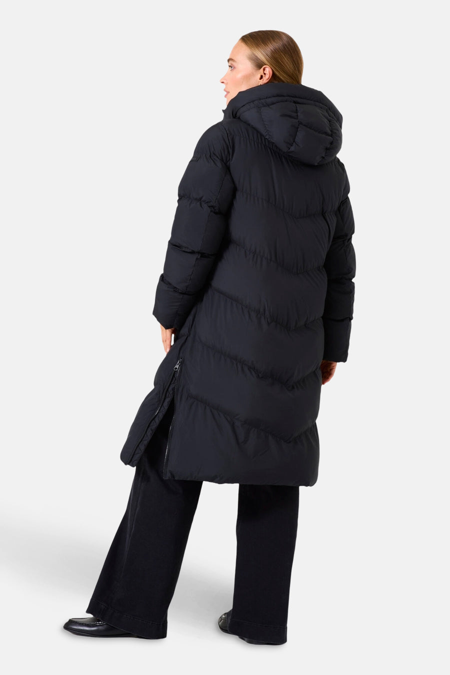 Zwarte lange jas van GARCIA, met capuchon en ritssluiting aan de zijkant, gedragen met een donkere broek.