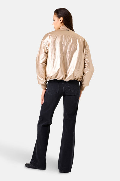 Veste courte beige de GARCIA, vue de dos, avec des jeans noirs évasés.