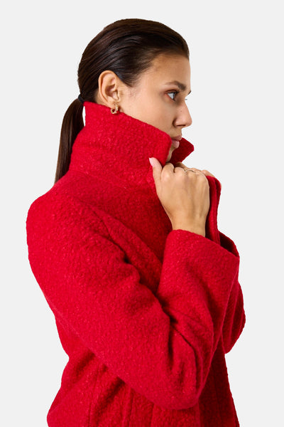 Veste longue rouge de GARCIA, texturée avec col montant, portée par un mannequin en vue de côté.
