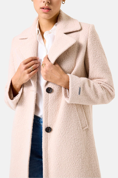 Veste longue beige de GARCIA, texturée avec deux boutons noirs, portée sur une chemise blanche et un jean.
