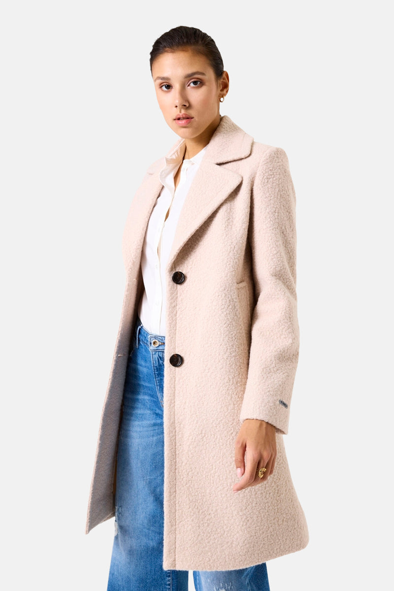 Lange beige jas van GARCIA, gedragen met een wit overhemd en een blauwe spijkerbroek.