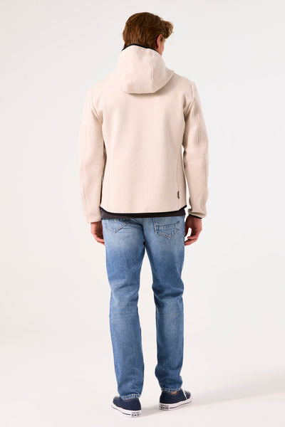 Beige regenjas van GARCIA, met capuchon, gedragen met een blauwe spijkerbroek en marineblauwe sneakers, van achteren gezien.