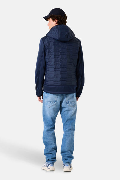 Veste de pluie bleu de GARCIA, avec capuche et motif géométrique matelassé sur le dos, portée avec un jean délavé.