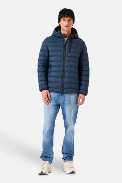 Veste de pluie bleue de GARCIA, portée avec un bonnet et un jean décontracté.