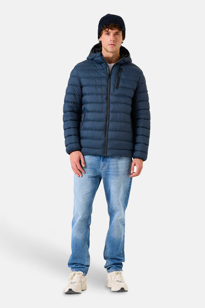 Veste de pluie bleue de GARCIA, portée avec un bonnet et un jean décontracté.