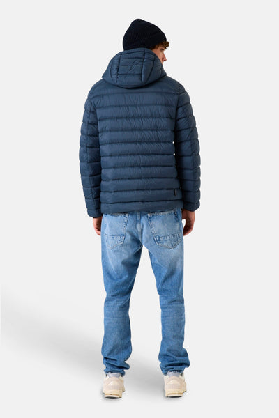 Veste de pluie bleue de GARCIA, avec capuche, portée avec un jean bleu et des baskets.
