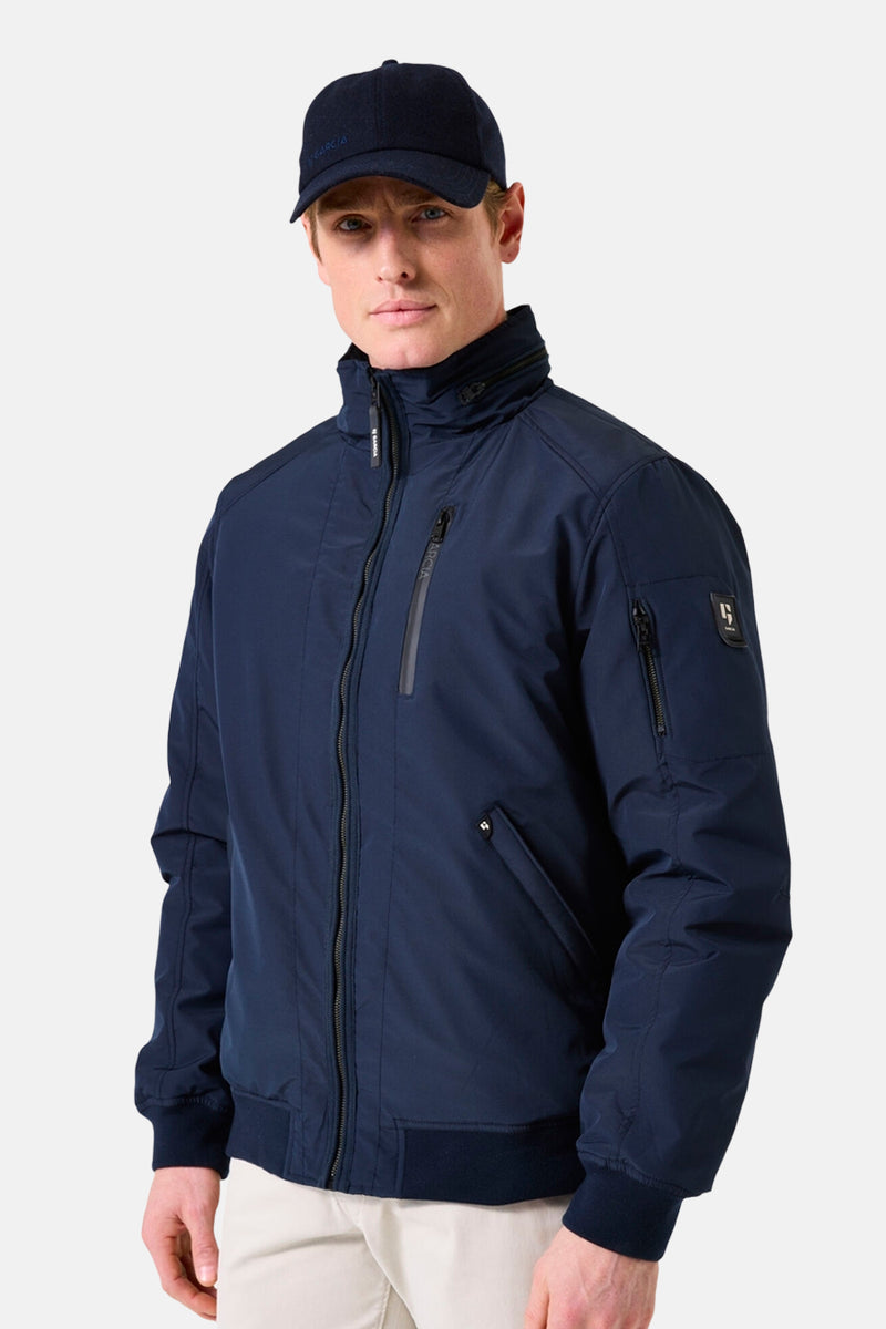 Veste de pluie bleue de GARCIA, avec fermeture éclair apparente et casquette bleu marine.