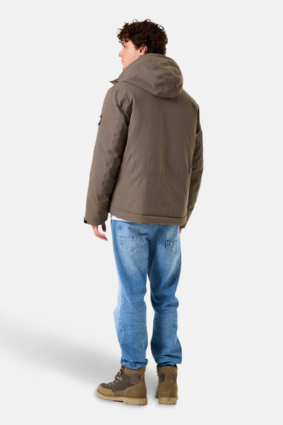 Veste de pluie kaki de GARCIA, vue de dos, portée avec un jean bleu et des bottines marrons.