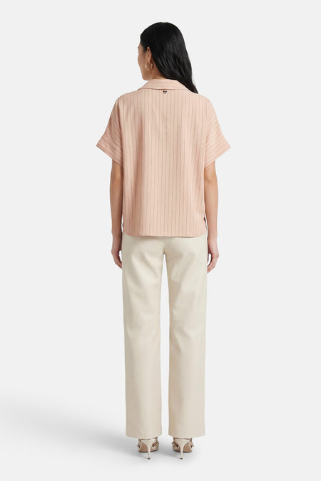 Chemise beige rayée, de AMELIE ET AMELIE, à manches courtes, vue de dos, portée avec un pantalon et des escarpins ivoire.
