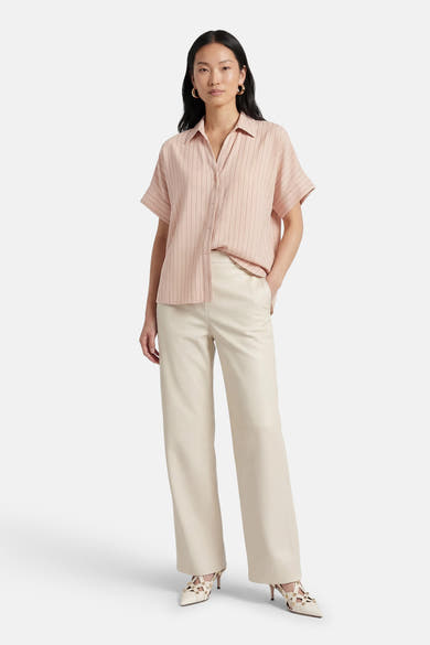 Beige gestreept overhemd met verticale strepen van AMELIE ET AMELIE, gedragen met een crèmekleurige broek en witte hakken.