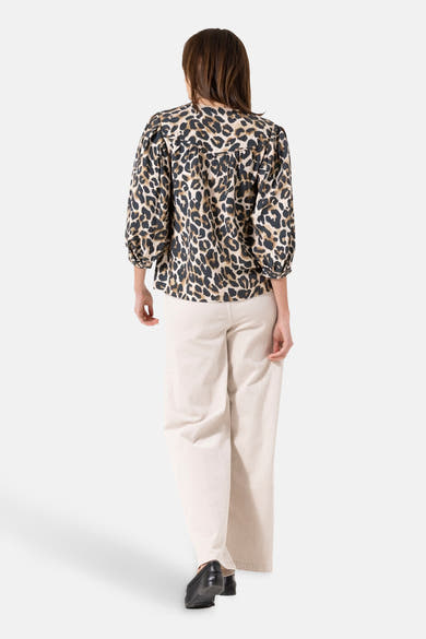 Multikleurige blouse van GARCIA, met luipaardprint, driekwartmouwen en een witte broek.