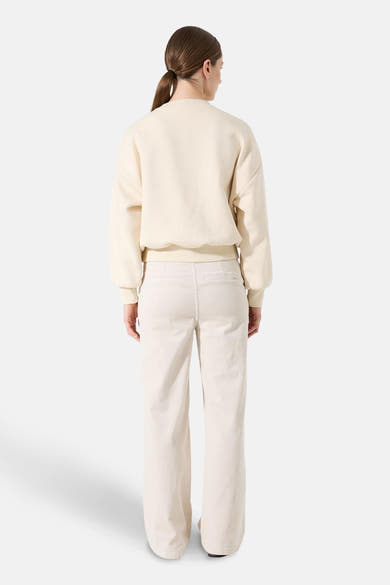 Sweat écru de GARCIA, manches longues et coupe décontractée, porté avec un pantalon beige en velours côtelé.