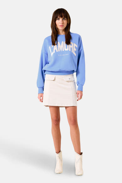 Sweat-shirt bleu de GARCIA avec inscription blanche, porté avec une jupe beige et des bottines.