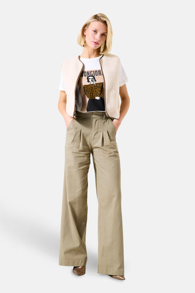 Moufloze fauxbonten jas van GARCIA, gedragen over een bedrukt T-shirt en een wijde kaki broek.