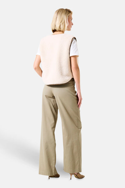 Beige shearling bodywarmer van GARCIA, gedragen over een wit T-shirt, met een kaki high-waisted broek.