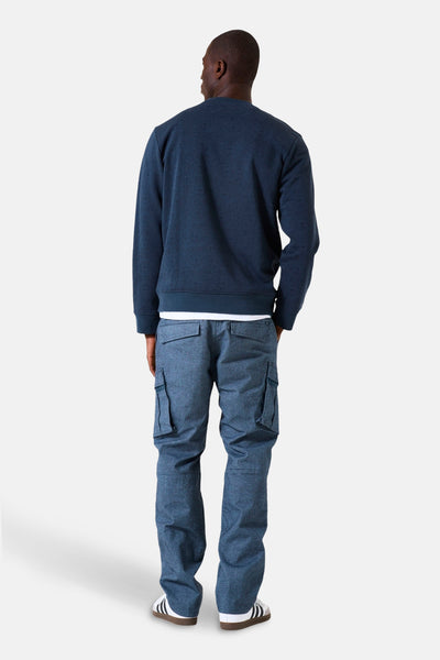 Blauwe trui met opstaande kraag van GARCIA, met een zichtbaar wit T-shirt en een blauwe cargobroek.